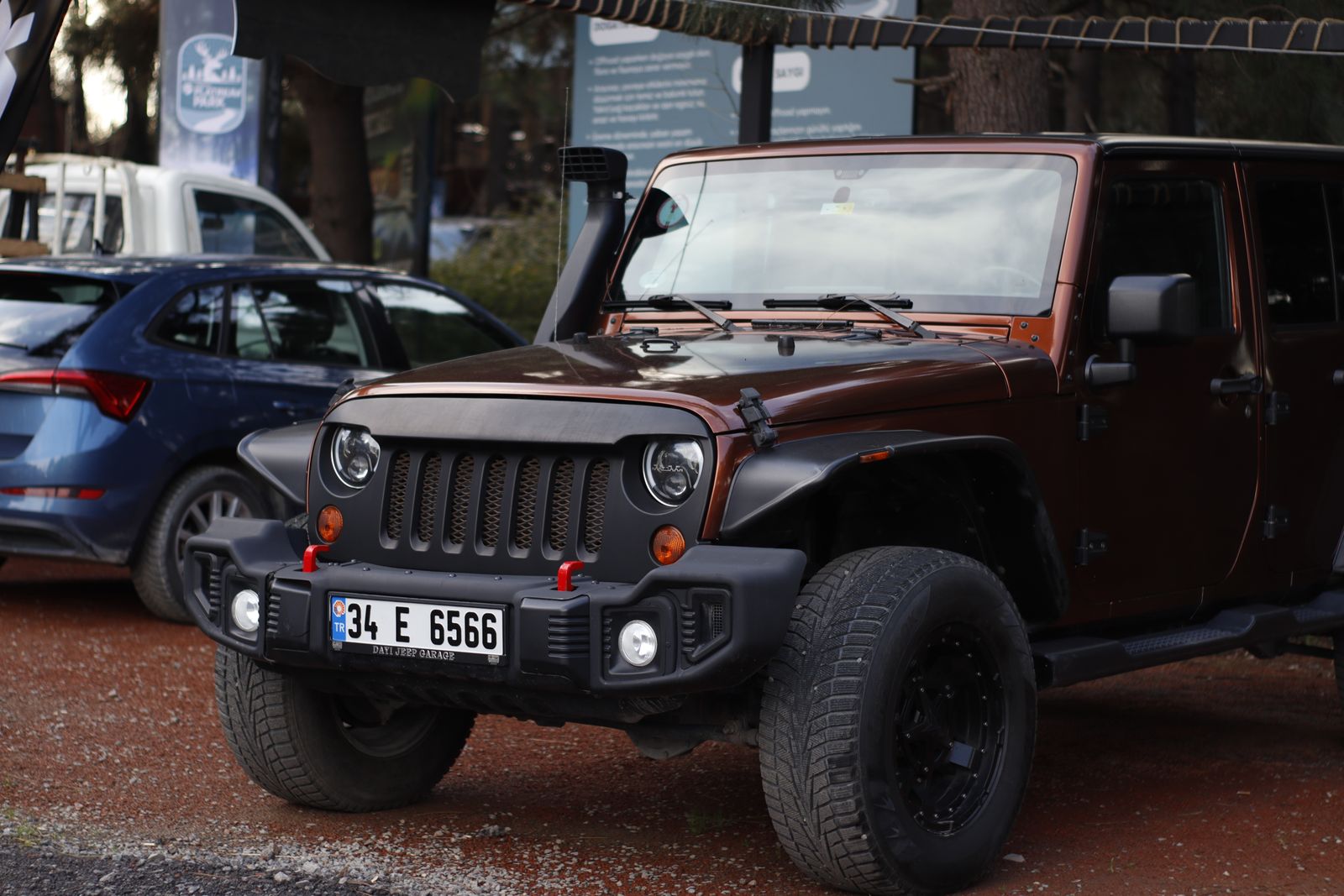 Close-up of a parked Jeep Wrangler with license plate, showcasing its rugged design in an outdoor setting.